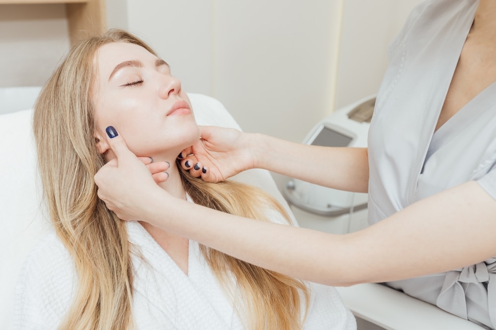 Expert cosmetologist analyzing a patient’s facial skin before performing SmartXide DOT laser resurfacing, a precision treatment for skin rejuvenation, texture improvement, and anti-aging care.